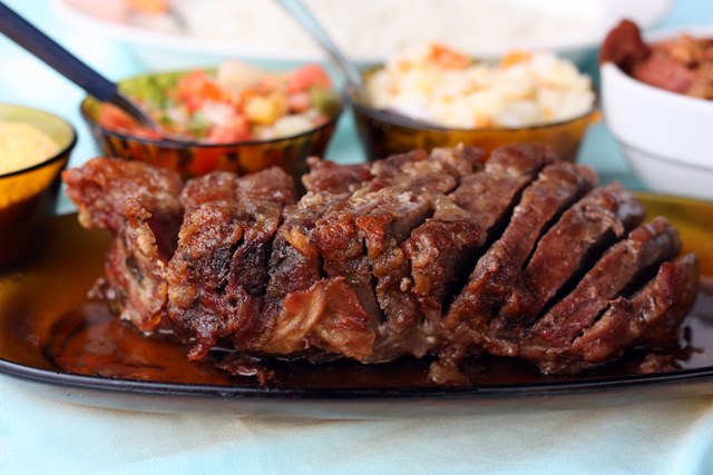 Legendas: Picanha de novilha, assada no forno apenas no sal grosso, é um dos pratos mais queridos do restaurante do Clóvis