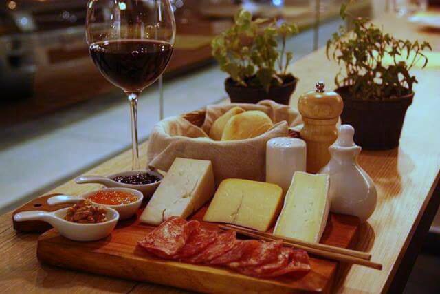 Elegância e sabor: vinho, queijos, presuntos, geleias e pães no Bon Vin