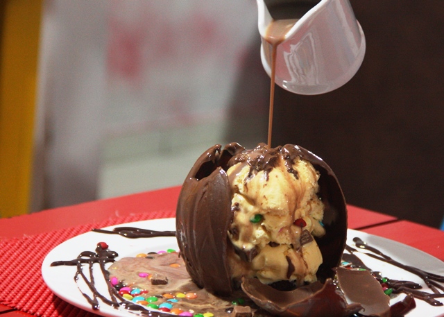 E bola é derretida por uma calda de brigadeiro quente