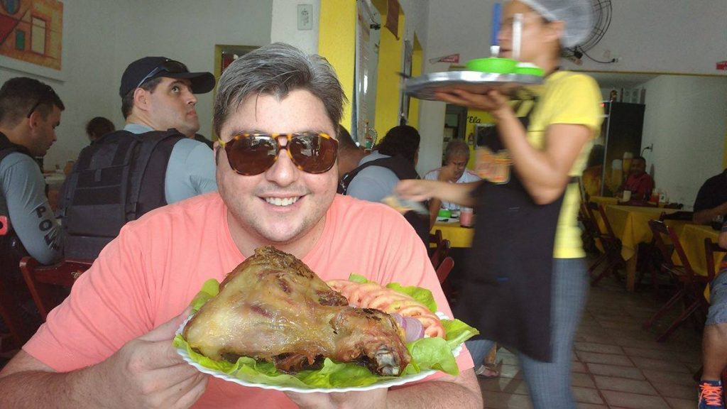 Chef Serginho Jucá provando o joelho (tamanho família) de porco do Tonho