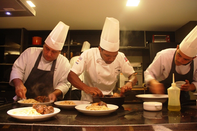 Jonatas com parte de sua equipe na cozinha aberta aos comensais